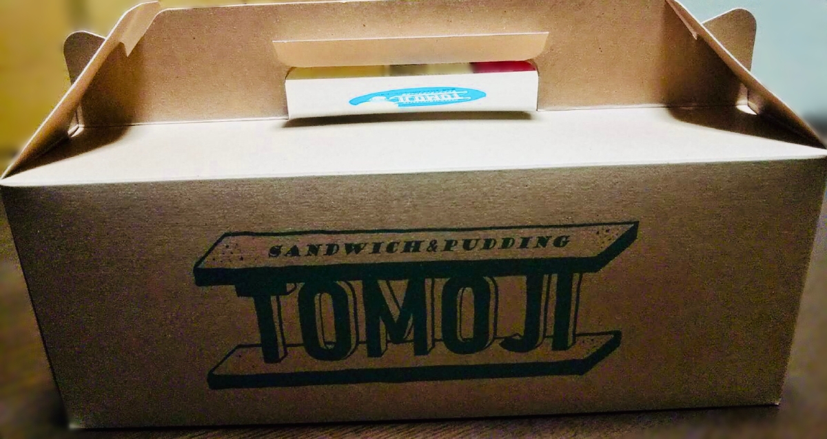 「サンドイッチとプリンのお店TOMOJI」のテイクアウト用の箱